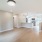 Spacious and well lit kitchen with wood flooring and stainless steel appliances