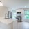 Spacious and well lit kitchen with wood flooring and stainless steel appliances